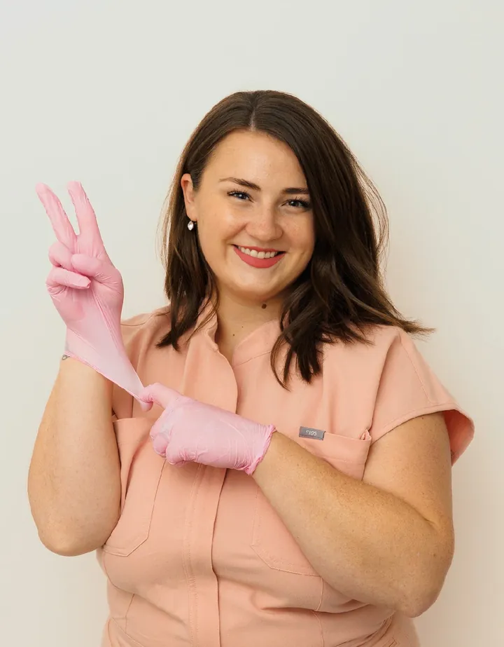 Shannon pulling on pink gloves and smiling
